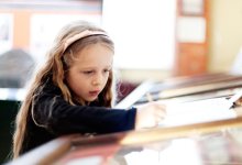 Girl taking notes on a clipboard at an exhibit