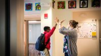 Teacher and student high-fiving, demonstrating proactive classroom management