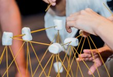 Elementary students using creativity, marshmallows, and spaghetti sticks to build structures