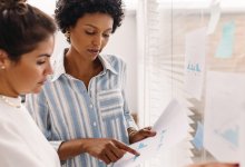 Two coworkers looking at data