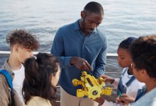 Adult showing robot to kids