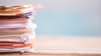 Stack of papers on a wood table