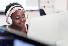 High school student using a computer with headphones
