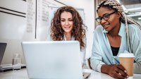 Two women working on a laptop together
