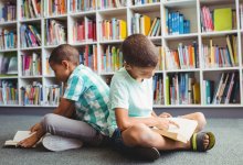 Photo of two elementary age boys reading books